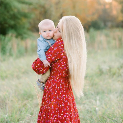 A mother kissing and carrying a boy